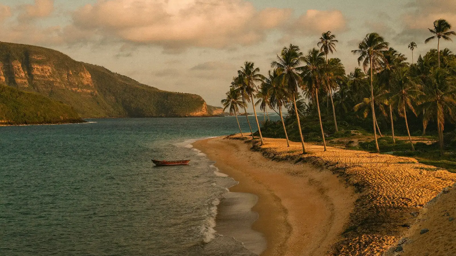 Enseada de areia dourada com coqueiros na Costa Dourada